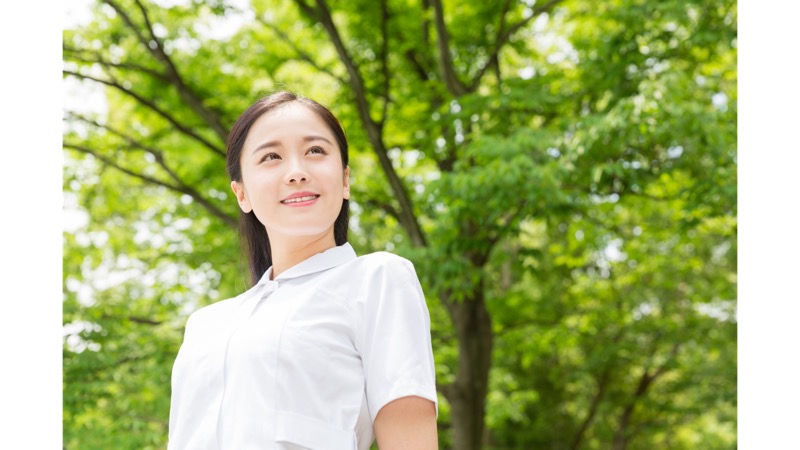 緑のなかで微笑む訪問看護師